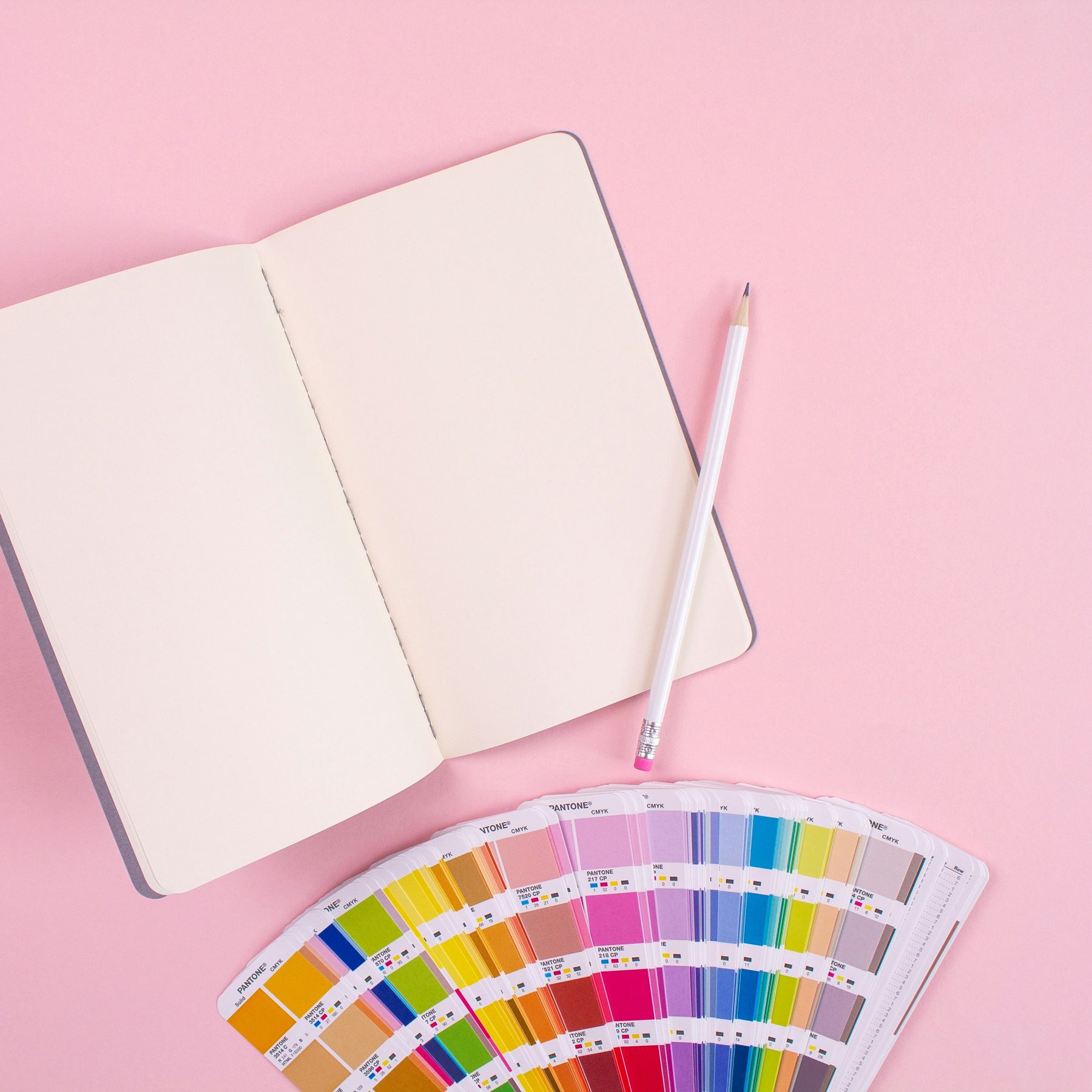 Color reference fan, notebook and pencil used for creative planning
